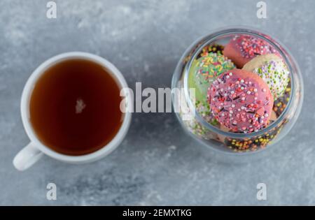 Verre avec plein de biscuits et une tasse de thé Banque D'Images