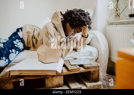 Femme regardant dans le miroir tout en étant couché sur le lit à la maison Banque D'Images