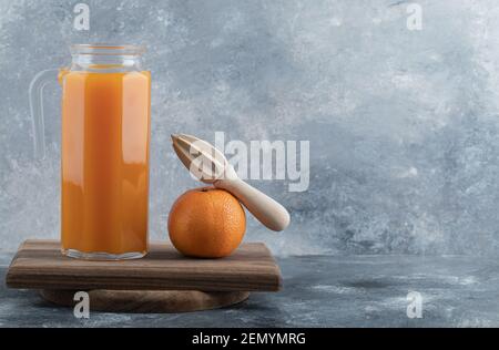 Jus frais et orange avec alésoir sur bois Banque D'Images