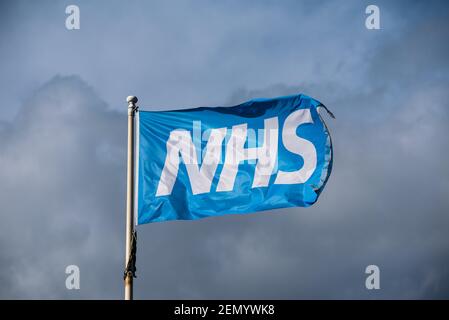 Drapeau NHS bleu agité isolé devant un ciel nuageux ciel Banque D'Images