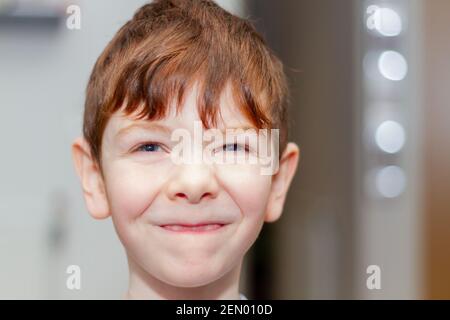 Portrait d'un garçon de six ans mignon, aux cheveux rouges, aux yeux bleus Banque D'Images