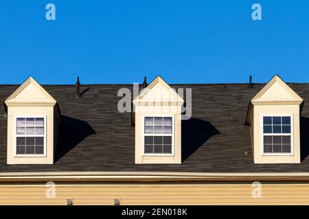 Gros plan image isolée de trois faux dortoirs (style gabbré) sur un toit couvert de bardeaux dans une maison moderne. Ces fonctions ne sont pas fonctionnelles b Banque D'Images