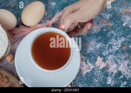 Une tasse de thé sur fond bleu texturé Banque D'Images