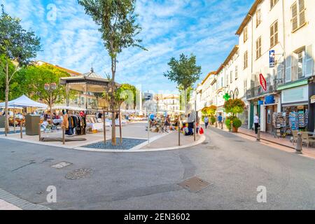 Les commerçants vendent leurs antiquités et objets de collection à l'Antibes Marché aux puces de la Place Nationale dans le village balnéaire d'Antibes, France Banque D'Images