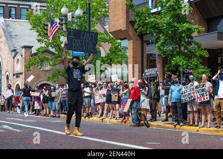 Un manifestant tenant une plaque exprimant son opinion, se promène sur court Street avec le soutien d'alliés sur les trottoirs, pendant la manifestation.des centaines de manifestants se tiennent devant le greffier des tribunaux du comté d'Athènes pour protester contre la mort de George Floyd par l'officier de police de Minneapolis Derek Chauvin, Racisme en Amérique et brutalité policière. La manifestation a duré quelques heures, a impliqué des orateurs et a inclus une marche vers le sud sur court Street, sur College Green, à travers la classe Gateway, vers le nord sur N College St. et vers l'ouest sur E Washington St. Banque D'Images