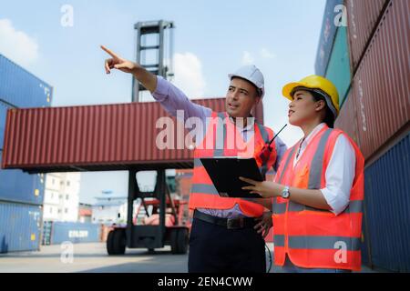 Une travailleuse asiatique explique une liste de contrôle des inspections de conteneurs au superviseur du terminal du dépôt de conteneurs. Banque D'Images