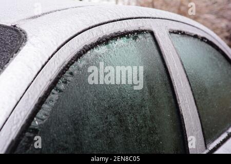 Vitres de voiture gelées, vitres automatiques après une pluie verglaçante. Comment dégeler, dégivrer les vitres de voiture par temps froid en hiver. Banque D'Images