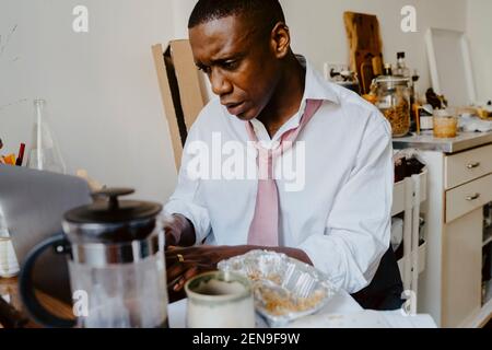 Homme d'affaires inquiet travaillant sur un ordinateur portable dans le salon Banque D'Images