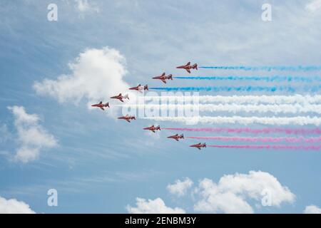 Les flèches rouges indiquent que l'équipe est en action. L'équipe aérobatique de la Royal Air Force. Traces de vapeur rouge et bleue. Banque D'Images