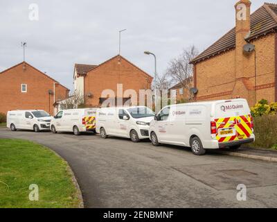 Quatre fourgonnettes blanches Openreach pour sous-traitants garées de bout en bout sur une rue de banlieue, Northampton, Royaume-Uni ; montage fibre large bande à une maison. Banque D'Images