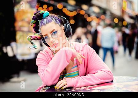 Sympa et sympa, cool, cool, hipster jeune fille qui écoute de la musique écouteurs dans la rue Banque D'Images