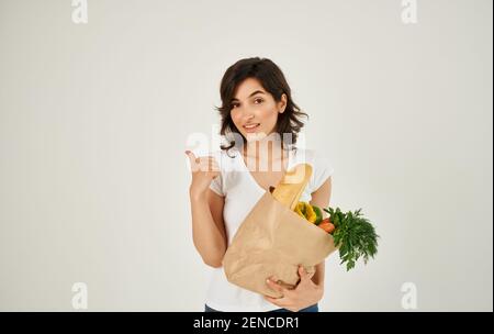 Brunette dans un T-shirt blanc mangeant des aliments sains Banque D'Images