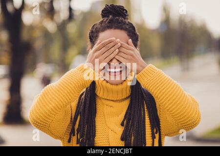 Portrait de jeune heureuse gaie positive bonne humeur afro femme sourire couvrez les yeux avec les mains à l'extérieur Banque D'Images