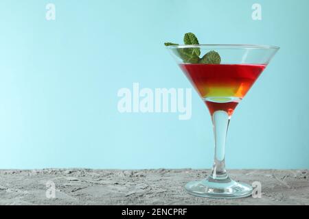 Verre à cocktail avec gelée de fraise et d'orange sur fond bleu Banque D'Images