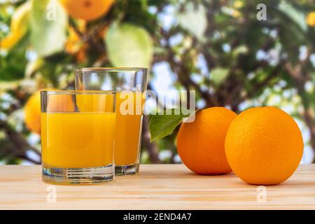 Deux verres de jus d'orange sur fond de nature. Concept fruit. Banque D'Images