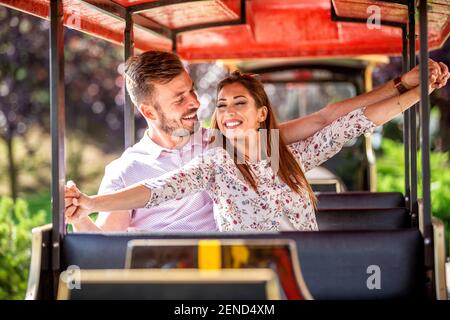 Un jeune couple partage des moments inoubliables lors d'une excursion en mini-train Banque D'Images