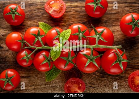 Tomates cerises fraîches sur fond de bois avec épices. La nourriture. Vue de dessus. Banque D'Images