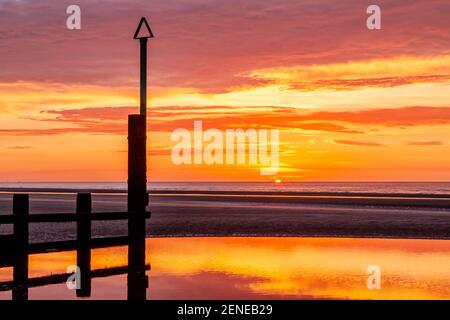Coucher de soleil sur la plage de Rhyl à marée basse au nord Côte du pays de Galles Banque D'Images