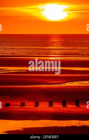Coucher de soleil sur la plage de Rhyl à marée basse au nord Côte du pays de Galles Banque D'Images