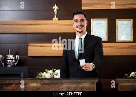 Réceptionniste tenant une carte-clé dans sa main Banque D'Images