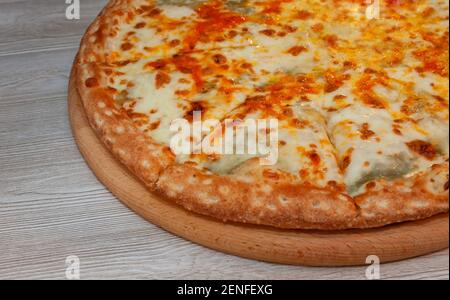 Quatre pizzas au fromage sur une planche Banque D'Images