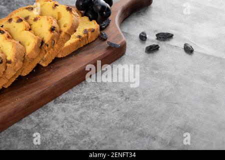 Tranches de roulette fraîches avec raisin sur planche à découper en bois Banque D'Images