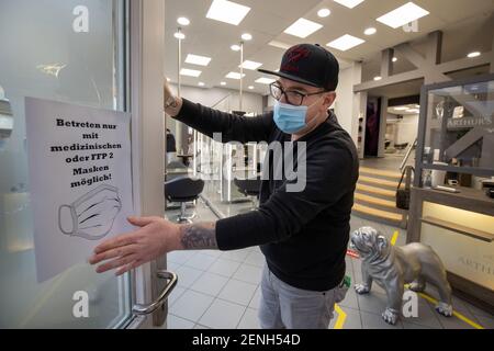 Gotha, Allemagne. 26 février 2021. Le coiffeur André Amberg met un avis sur son salon 'Arthur's Friseure' de porter des masques médicaux bouche-nez pour éviter l'infection par le nouveau coronavirus. À partir de 01.03.2021 coiffeurs sont autorisés à servir leurs clients de nouveau après une pause forcée d'environ dix semaines. Credit: Michael Reichel/dpa-Zentralbild/dpa/Alay Live News Banque D'Images