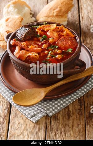 Calllos espagnols à base de tripe, chorizo, saucisse de sang et pois chiches dans une sauce épicée dans un bol sur la table. Vertical Banque D'Images