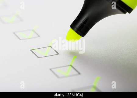 Marqueur jaune avec marqueurs sur la feuille de liste de contrôle. Concept de la tâche terminée de la liste de contrôle. Banque D'Images