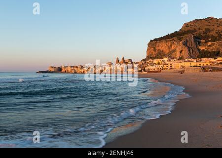 Italie, Sicile, Cefalu, la plage et surf avec Cefalu et Rocca en arrière-plan Banque D'Images