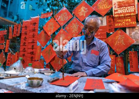 HONG KONG, HONG KONG SAR, CHINE : 13 FÉVRIER 2021. Une calligraphie sifu (maître) travaille sur Cat Street, près du temple Man Mo Soho Hong Kong qui produit du han Banque D'Images