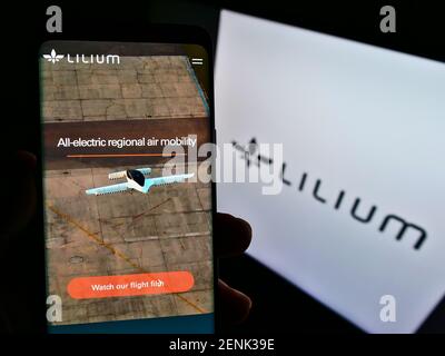 Personne tenant un téléphone portable avec la page web du fabricant allemand d'avions Lilium GmbH (Lilium Jet) à l'écran avec logo. Concentrez-vous sur le centre de l'écran du téléphone. Banque D'Images