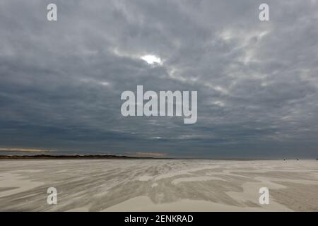 Tempête de sable soufflant sur la vaste plage sous une obscurité ciel en hiver Banque D'Images