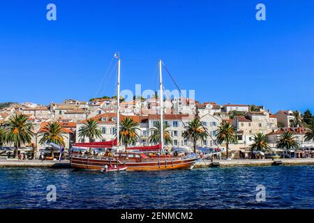 Hvar, Croatie - 2 octobre 2011 : vue sur un bateau dans le port de Hvar avec des maisons traditionnelles en arrière-plan Banque D'Images