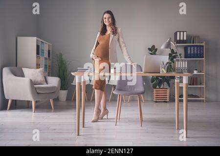 Photo portrait d'une femme enceinte debout sur une chaise bureau moderne Banque D'Images