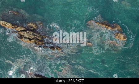 Vue aérienne des vagues qui tourbillonnaient autour des rochers de l'océan Banque D'Images
