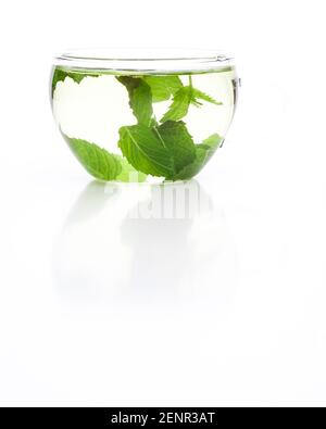 Thé en verre avec feuilles de menthe poivrée isolées sur fond blanc Banque D'Images