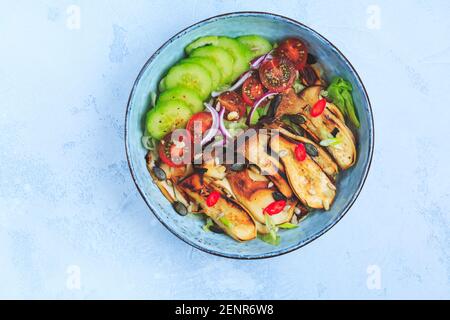 Bol à salade avec rôtissoire, champignons d'huîtres, tomate, concombre et oignon rouge. Repas sain de légumes. Banque D'Images