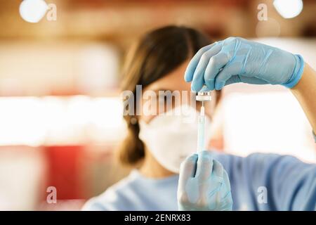 GRENADE, ANDALOUSIE, ESPAGNE. 26 FÉVRIER 2021. Vaccination de masse contre Covid-19, à l'aide du vaccin d'AstraZeneca. L'infirmière charge la seringue avec le vaccin. Banque D'Images