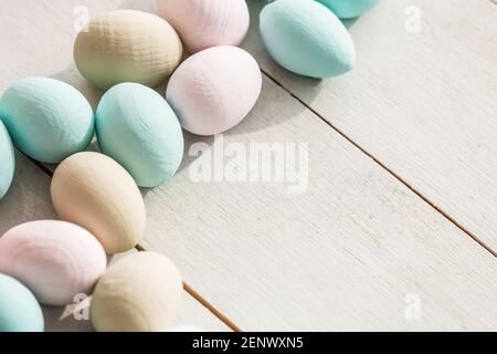 Oeufs de Pâques en Coloeful nichent sur un fond de couleur pastel avec l'espace. Banque D'Images