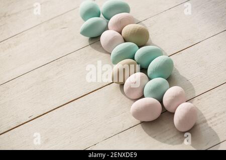 Oeufs de Pâques en Coloeful nichent sur un fond de couleur pastel avec l'espace. Banque D'Images