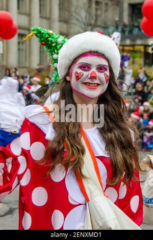 Une heureuse clown féminine à l'occasion de la 109e édition de la Parade du Père Noël. Plus d'un demi-million de personnes assistent à la parade chaque année. Banque D'Images