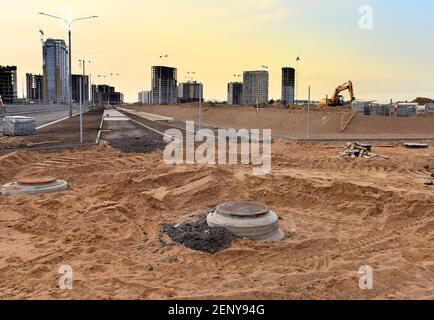 Crier le sable pour poser des dalles et des bordures de pavage et des blocs de béton sur le chantier de construction. Processus d'installation de briques de pavage dans le piéton Banque D'Images