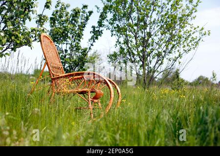 Fauteuil à bascule en osier dans le jardin, détente et nature Banque D'Images