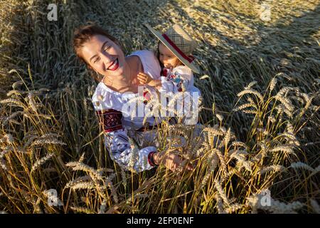 la mère avec sa fille joue dans le champ de blé Banque D'Images