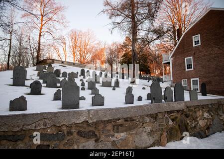 Les arbres d'hiver brillent au coucher du soleil sur le terrain de terriers d'Old Hill sur Monument Square, le plus ancien cimetière de la ville historique de Concord, Massachusetts, États-Unis. Banque D'Images