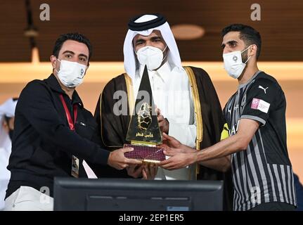 Doha, Qatar. 26 février 2021. Xavier Hernandez (L) et Hassan al-Haydos (R), entraîneur en chef d'Al Sadd SC, reçoivent le trophée après avoir remporté le match final de la coupe du Qatar entre Al Sadd SC et Al Duhail SC à Doha, au Qatar, le 26 février 2021. Credit: Nikku/Xinhua/Alay Live News Banque D'Images