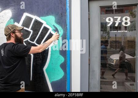 Columbus, Ohio, États-Unis. 3 juin 2020. Un spray artiste peint une fresque d'un poing élevé en solidarité avec le mouvement Black Lives Matter. Niko Latho et Raul Bermudez ont été invités par des entrepreneurs locaux à peindre des peintures murales sur les fenêtres à bord de North High St. pour rendre les vitrines plus attrayantes.des manifestants se sont rassemblés devant le Statehouse de l'Ohio et ont défilé vers le nord sur High St. dans une manifestation contre la brutalité policière. Racisme et meurtre de George Floyd par Derek Chauvin, agent de police de Minneapolis, le 25 mai 2020. Crédit : Stephen Zenner/SOPA Images/ZUMA Wire/Alay Live News Banque D'Images