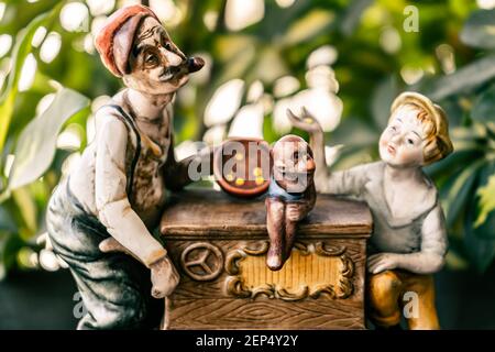 Vieux ornement par un auteur inconnu d'un vieil homme, d'un garçon et d'un singe de cirque dans une calèche musicale. Banque D'Images