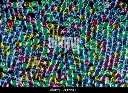 Galets en verre multicolore comme arrière-plan. Perles en forme de bol à poisson. Banque D'Images